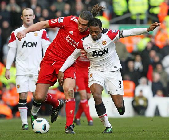 El jugador del Liverpool Andy Carroll (c) lucha por el balón con Patrice Evra durante su partido de la Premier League. Foto: EFE