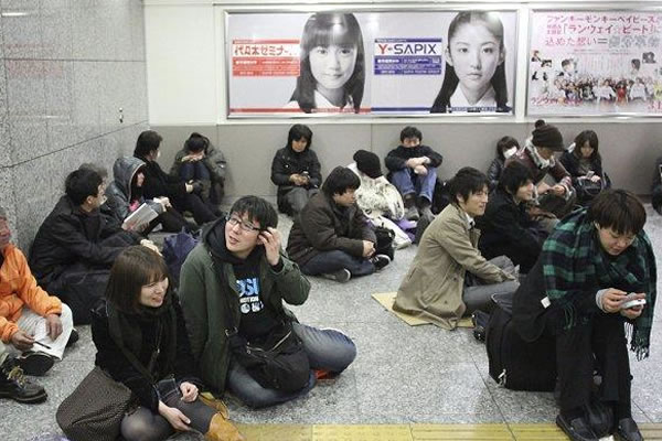 Jóvenes esperan el metro en Tokio. Foto: EFE