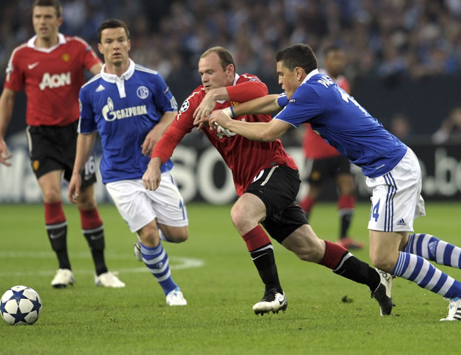 Kyriakos Papadopoulos (d) del FC Schalke 04 lucha por el balón con Wayne Rooney (c) del Manchester United. Foto: EFE