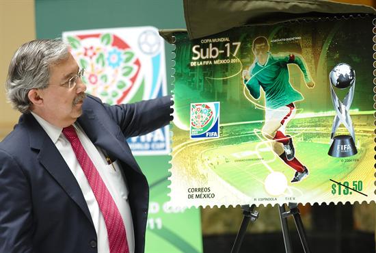 El director del Servicio Postal Mexicano, Pablo Salvador Reyes muestra el timbre postal alusivo al Mundial de fútbol Sub'17. Foto: EFE