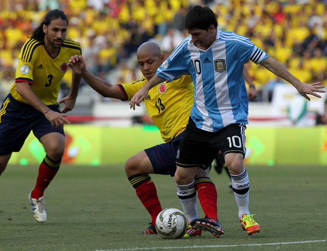 Lionel Messi disputa el balón con Gustavo Bolivar. Foto: EFE