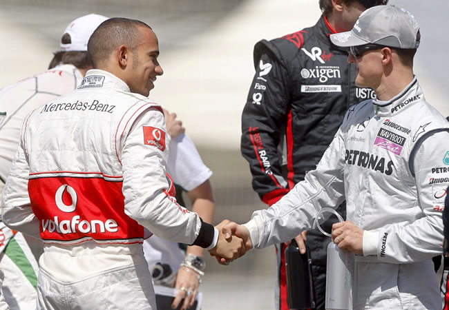 Lewis Hamilton (i) recibe el saludo de Michael Schumacher (d). Foto: EFE