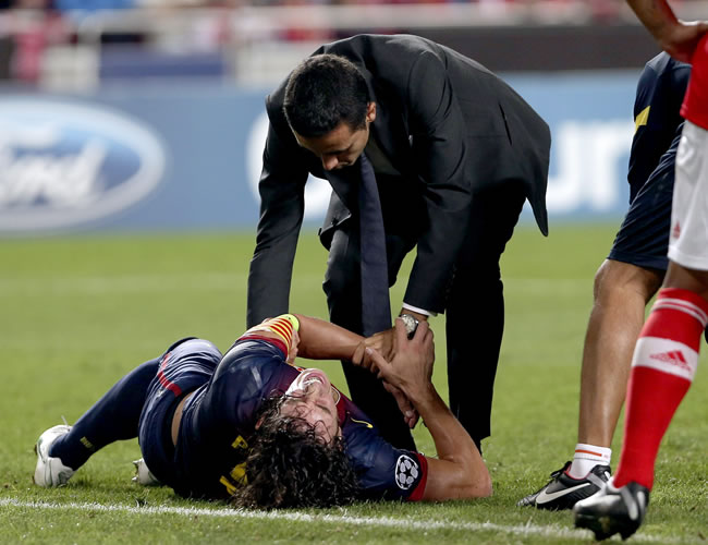 El jugador del Barcelona Carles Puyol (i), lesionado, es atendido en un partido de la Liga de Campeones ante el Benfica. Foto: EFE