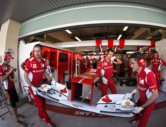 Los mecánicos de la escudería Ferrari trabajan en el monoplaza del español Fernando Alonso. Foto: EFE