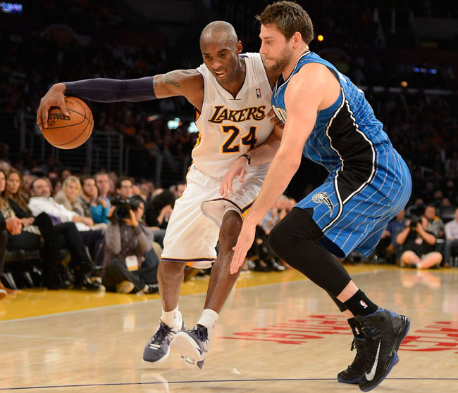 Kobe Bryant (L) de Los Angeles Lakers enfrenta la marca de  Josh McRoberts (R) de los Orlando Magic. Foto: EFE
