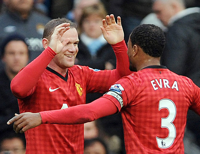 Wayne Rooney (i) es felicitado por Patrice Evra (d) por un gol para Manchester United. Foto: EFE