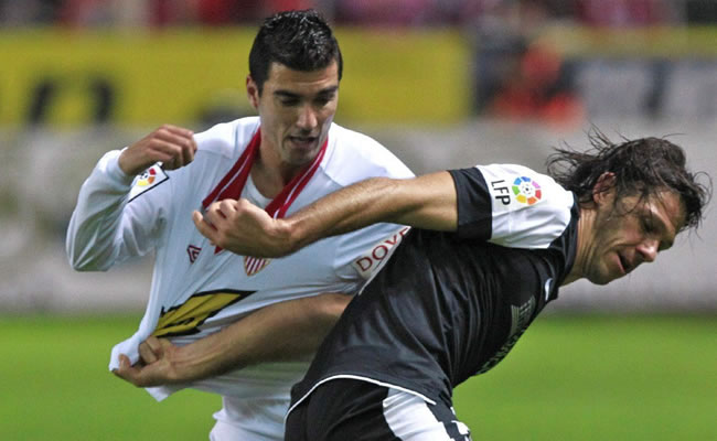 El centrocampista del Sevilla CF, José Antonio Reyes (i), lucha el balón con el argentino Martín Demichelis, del Málaga CF. Foto: EFE