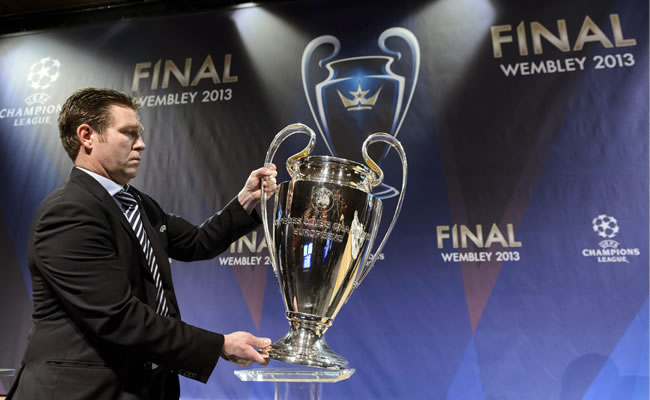 Un trabajador de la UEFA coloca el trofeo de la Liga de Campeones antes del inicio del sorteo de los octavos de final de la Liga de Campeones. Foto: EFE
