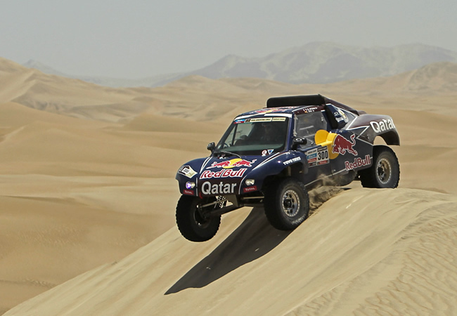 El auto del corredor catarí Nasser Al-Attiyah pasa una duna en la tercera etapa. Foto: EFE