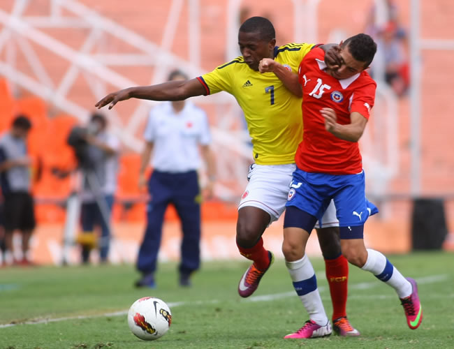 El chileno Cristian Cuevas (d) disputa el balón con el colombiano Mauricio Cuero (i). Foto: EFE