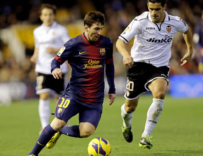 El delantero argentino del Barcelona Leo Messi (i) controla el balón ante el defensa portugués del Valencia Ricardo Costa. Foto: EFE