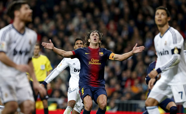 El defensa del FC Barcelona, Carles Puyol (c), rodeado por jugadores del Real Madrid. Foto: EFE