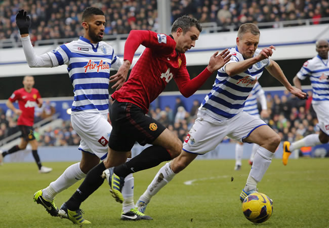 El delantero del Manchester United, Robin Van Persie, trata de superar dos rivales del QPR. Foto: EFE