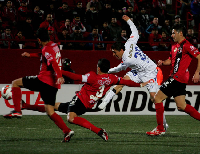 Diego Cabrera del equipo San Jose de Oruro (c) disputa el balón con Javier Gandolfi de Xolos. Foto: EFE