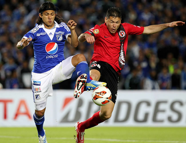 El jugador Pablo Aguilar (d) del Tijuana de México disputa un balón con Fredy Montero de Millonarios. Foto: EFE