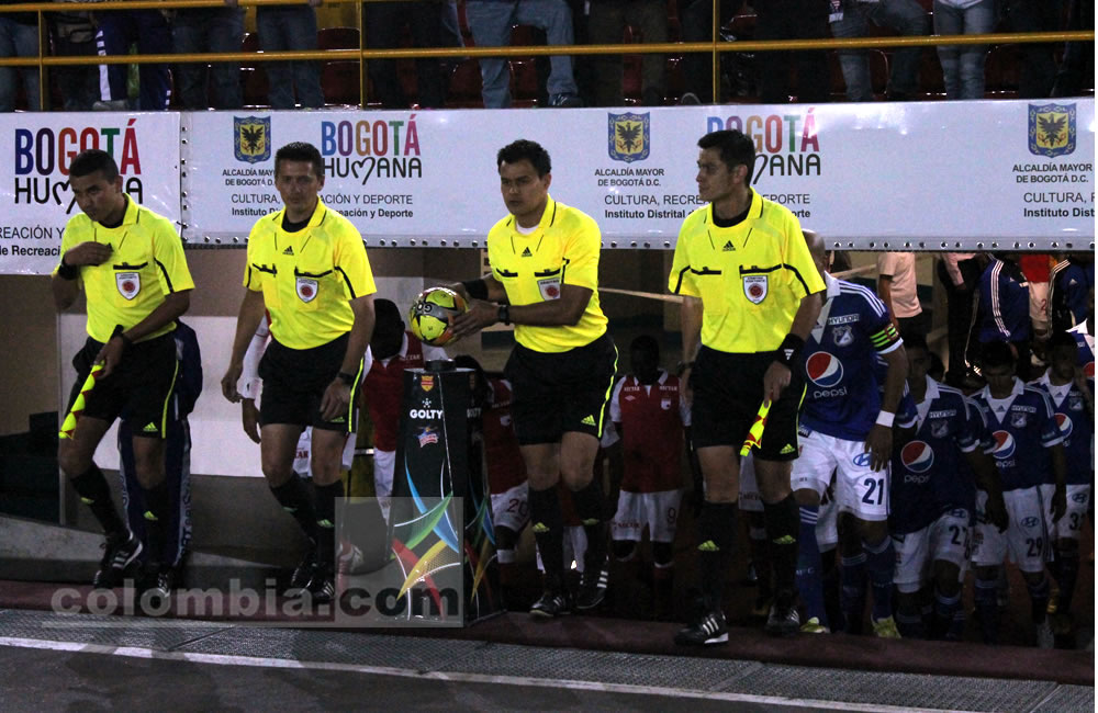 El árbitro del partido, Edilson Ariza, toma el balón en la salida al acto protocolario. Didier Moreno de Santa Fe (i) y Alex Díaz de Millonarios (d) disputan un balón. Foto: Interlatin