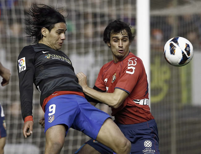 El delantero colombiano del Atlético de Madrid Radamel Falcao (i) pelea un balón con el defensa de Osasuna Alejandro Arribas. Foto: EFE