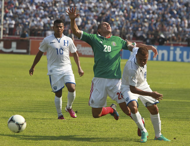 Los jugadores de Honduras Arnol Peralta (d) y Mario Martínez (i) disputan el balón con Jorge Torres Nilo (c) de México. Foto: EFE