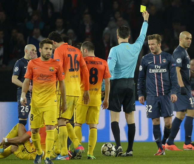 El centrocampista inglés del Paris Saint-Germain, David Beckham (2d) ve la tarjeta amarilla ante el Barsa. Foto: EFE