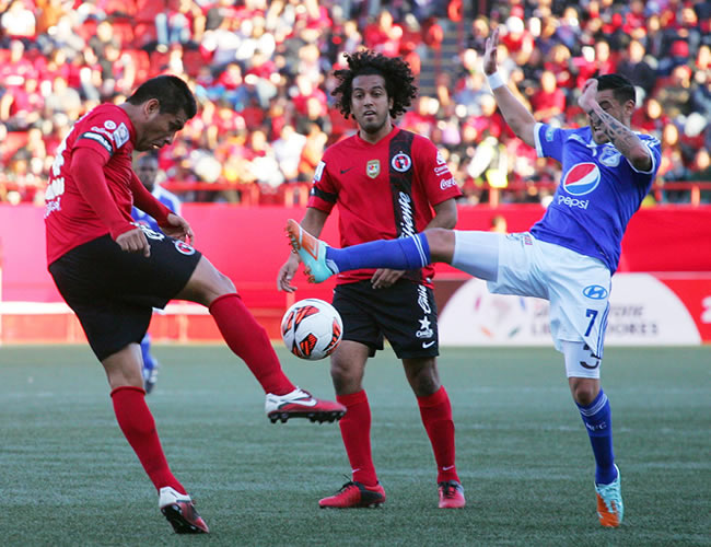 El jugador de Xolos, Alfredo González (i), disputa el balón con José Tancredi (d) de Millonarios. Foto: EFE