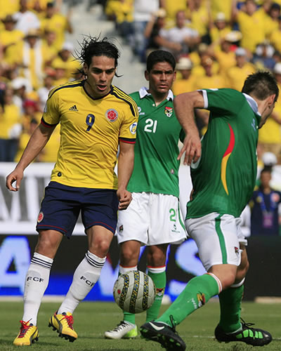 El jugador de Colombia, Falcao García, disputa el balón con Edward Zenteno (c) y Ronald García (d) de Bolivia. Foto: EFE
