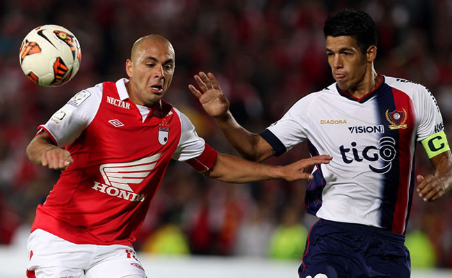 El jugador Julio Dos Santos (d) del Cerro Porteño de Paraguay disputa un balón con Omar Pérez (i) de Independiente Santa Fe. Foto: EFE