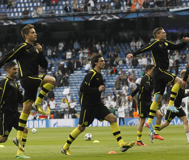 El defensa del Borussia Dortmund Mats Hummels (c) calienta junto a otros compañeros. Foto: EFE