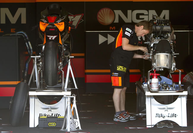 Un mecánico del equipo NGM hace preparativos en una moto. Foto: EFE