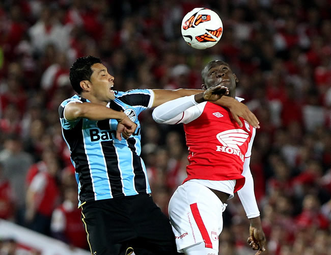 El jugador de Santa Fe Cristian Martinez (d) disputa el balón con André Santos (i) de Gremio de Brasil. Foto: EFE