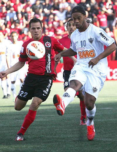 El jugador Juan Carlos Nuñez de Xolos de Tijuana (i) disputa el balón con Ronaldinho (d) del Atlético Mineiro. Foto: EFE