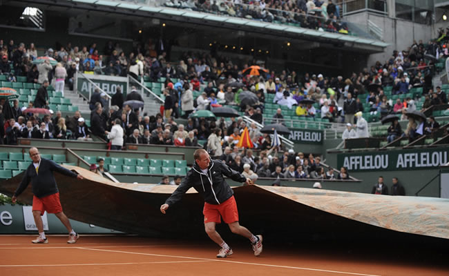 Los operarios cubren la pista a causa de la lluvia durante la segunda ronda del torneo de Roland Garros en París, Francia. Foto: EFE