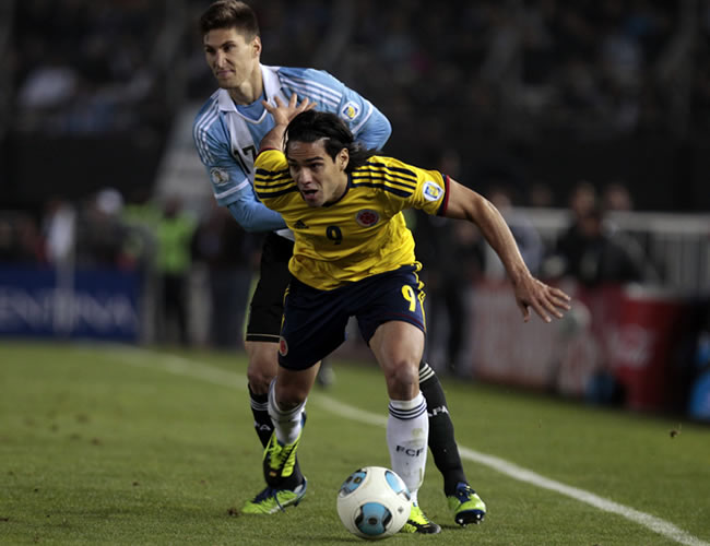El delantero de Colombia, Falcao García, supera la marca de Federico Fernández de Argentina. Foto: EFE