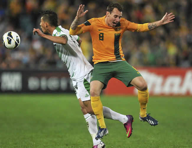 El defensa de la selección australiana Luke Wilkshire (d) lucha por el balón con el iraquí Dhurgham Ismael. Foto: EFE