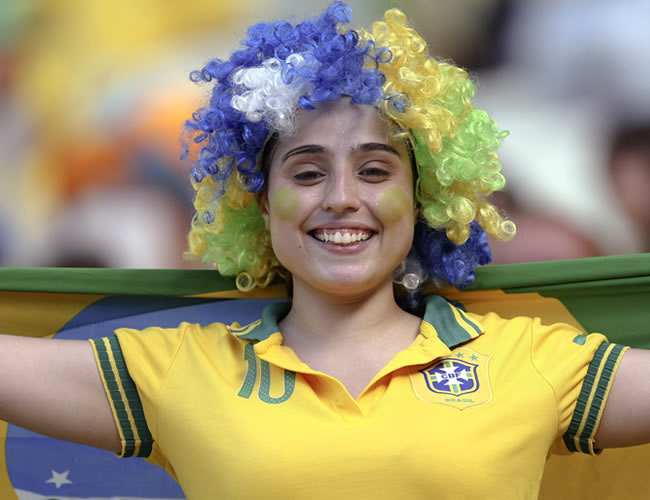 Una aficionada brasileña anima a su selección antes de comenzar el partido ante México. Foto: EFE