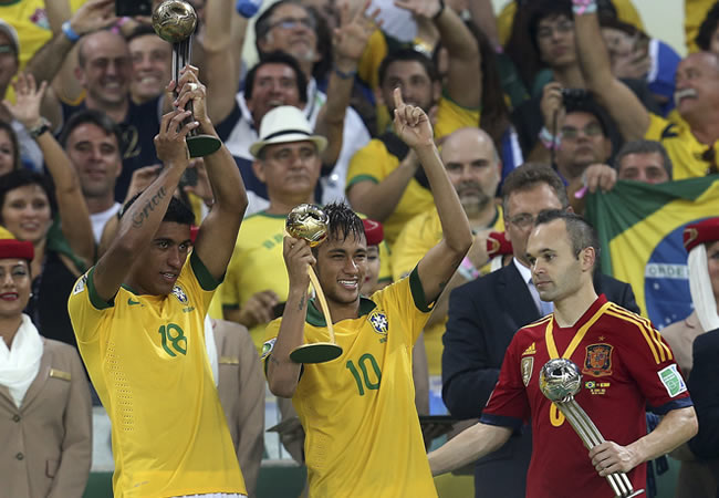 Los jugadores de la selección brasileña Paulinho (i) y Neymar muestran sus trofeos en presencia de Iniesta (d), de España. Foto: EFE