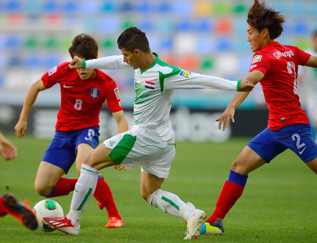 Ali Qasim (c) de Irak lucha por el balón con Sim Sangmin (d) y Lee Changmin de Corea del Sur. Foto: EFE