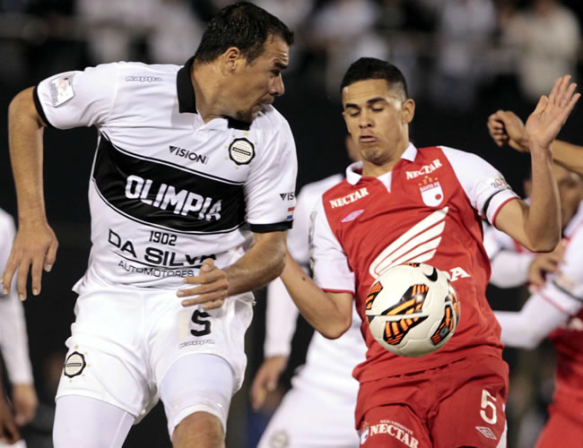El jugador del Independiente Santa Fe Yulián Anchico (d) disputa el balón con Julio Manzur (i) del Olimpia de Paraguay. Foto: EFE
