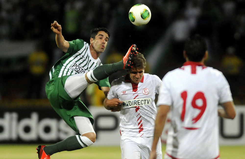 El jugador de Atlético Nacional, Juan Pablo Ángel (i), disputa el balón con Daniel Carrico (c) del Sevilla de España. Foto: EFE