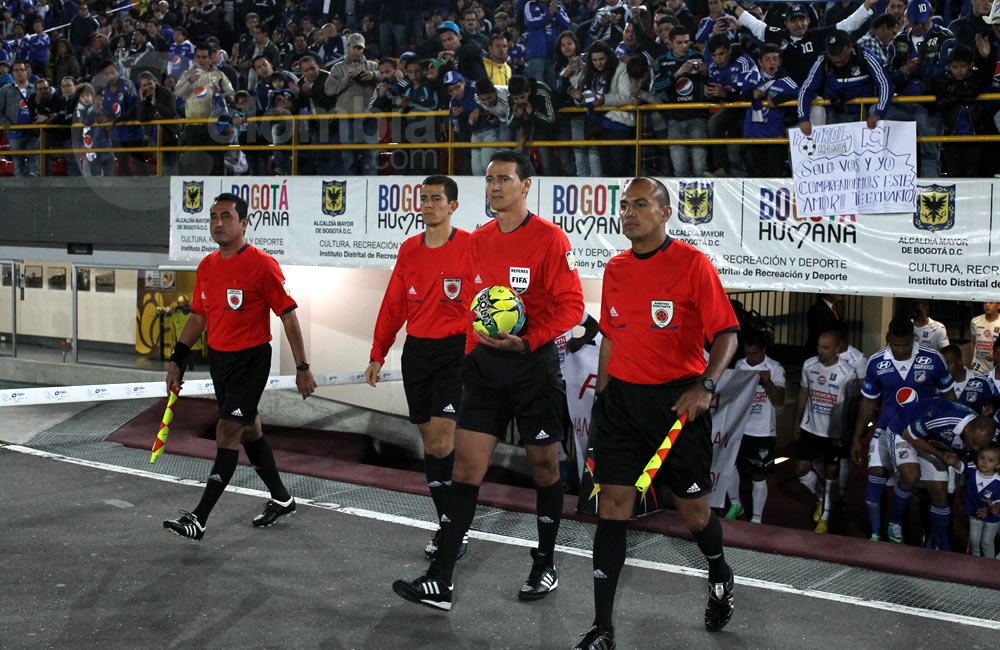 El árbitro colombiano FIFA, Wilmar Roldán (con el balón), encabeza la salida de los protagonistas del partido. Foto: Interlatin