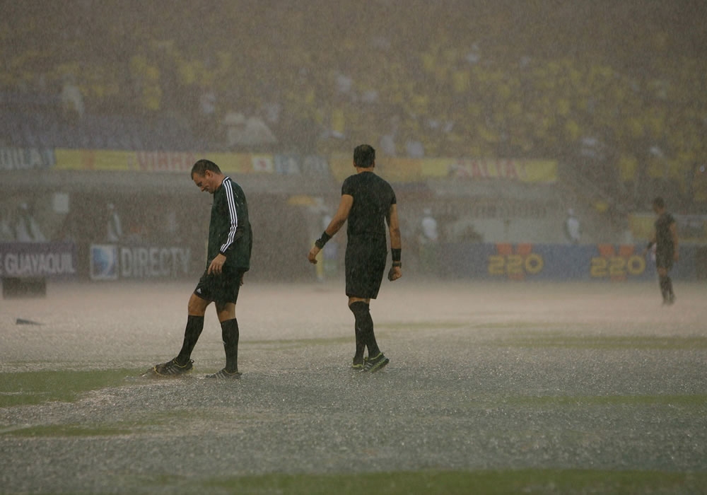 El grupo de árbitros del partido entre Colombia y Ecuador evalúa el estado de la cancha, durante una fuerte lluvia en Estadio Metropolitano en Barranquilla. Foto: EFE