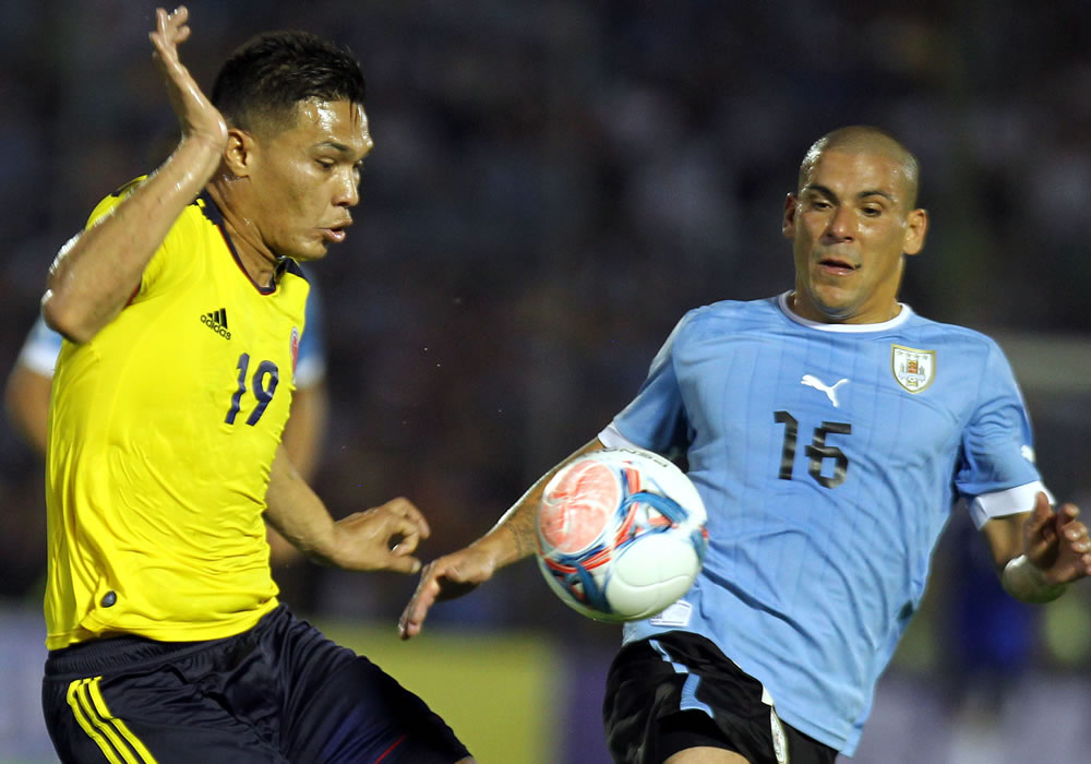 Teófilo Gutiérrez (i) de Colombia disputa el balón con Maximiliano Pereira (d) de Uruguay. Foto: EFE