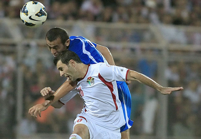 El jugador de Jordania, Saeed Murjan (d) disputa el esférico con Odil Ahmedov (i) de Uzbekistán. Foto: EFE