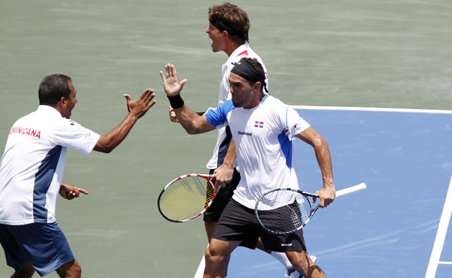 os tenistas dominicanos Víctor Estrella (d) y José Hernández (i) celebran con el capitán del equipo, Rafael Moreno (i). Foto: EFE