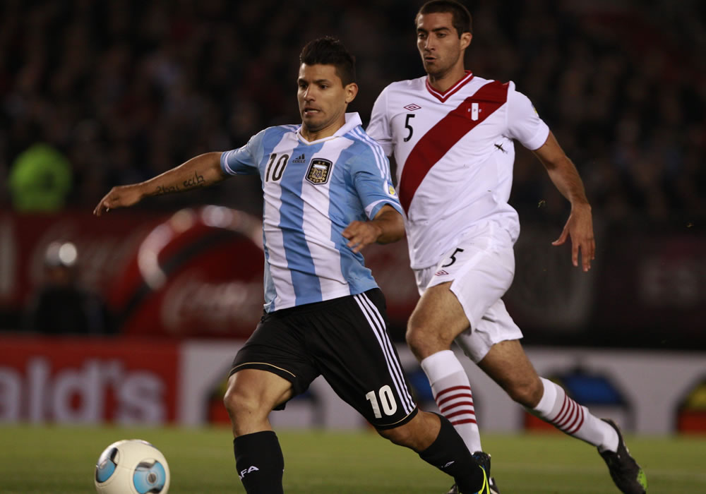 El jugador de Argentina Sergio Agüero (i) disputa un balón con Gianmarco Gambetta de Perú. Foto: EFE