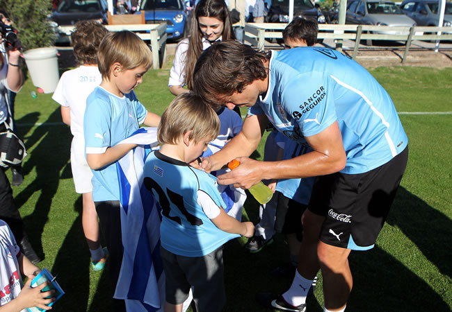 El jugador de la selección de Uruguay Diego Lugano (d), firma autógrafos luego de un entrenamiento. Foto: EFE