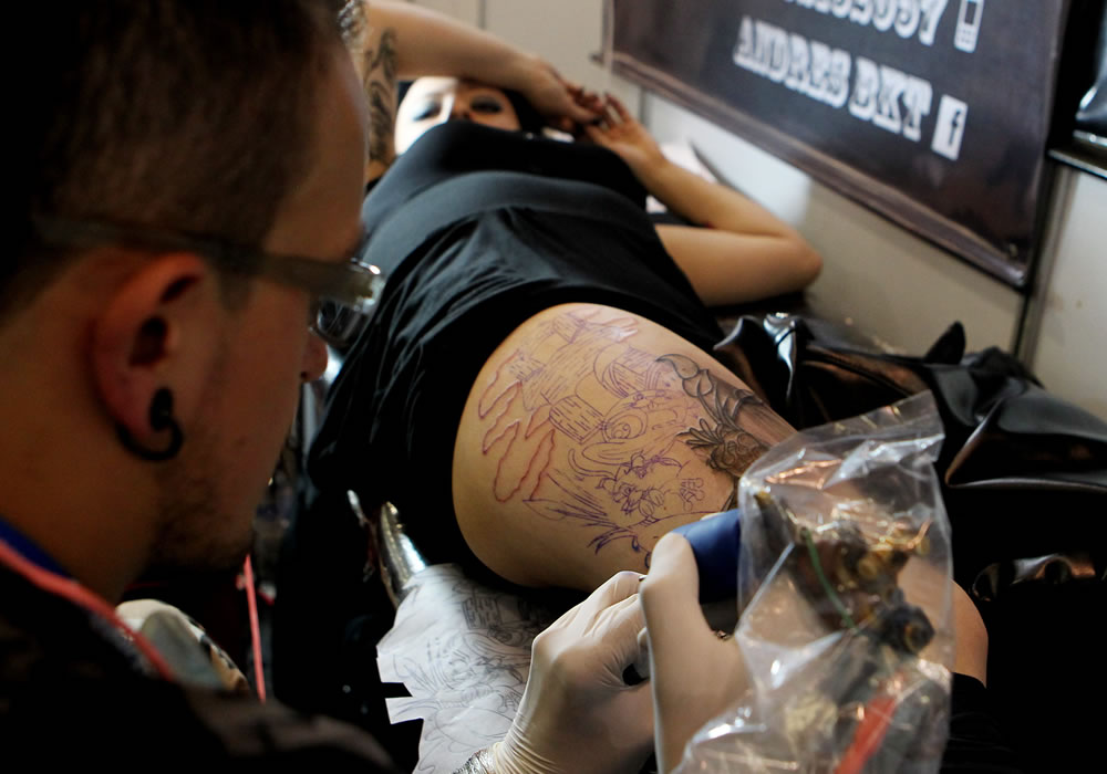 Una mujer es tatuada en la Séptima Convención Internacional de Tatuadores, en Bogotá. Foto: EFE