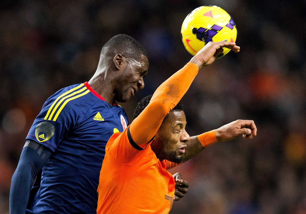 El jugador de Holanda Jeremain Lens (d) disputa el balón con Cristian Zapata. Foto: EFE