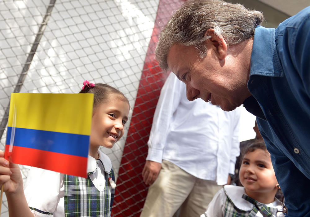 Foto cedida por la presidencia de Colombia del mandatario Juan Manuel Santos mientras saluda a una niña. Foto: EFE