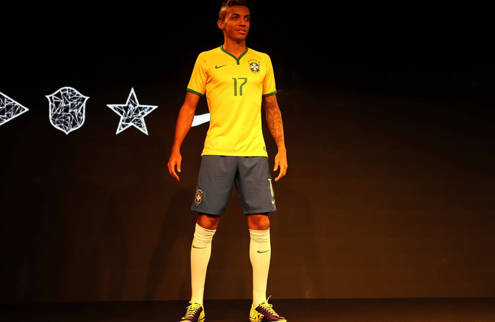 El futbolista brasileño Luiz Gustavo exhibe la camiseta con la que Brasil jugará el Mundial. Foto: EFE