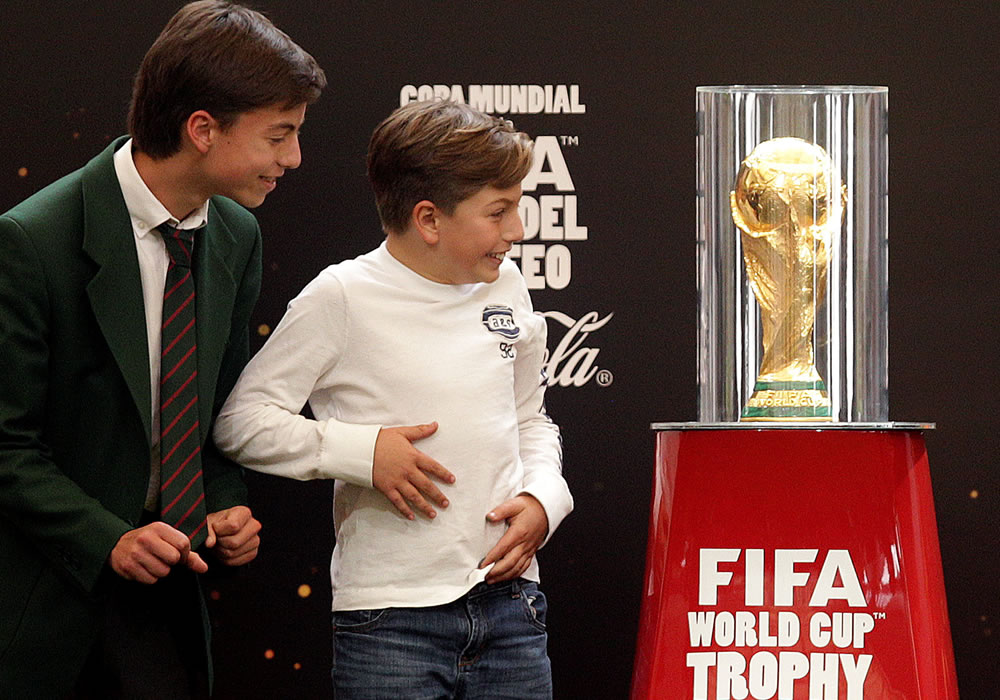Dos niños observan el Trofeo de la Copa Mundial de la FIFA en Bogotá (Colombia). Foto: EFE